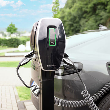 MENNEKES laadpaal op een paal naast een elektrische wagen op een oprit