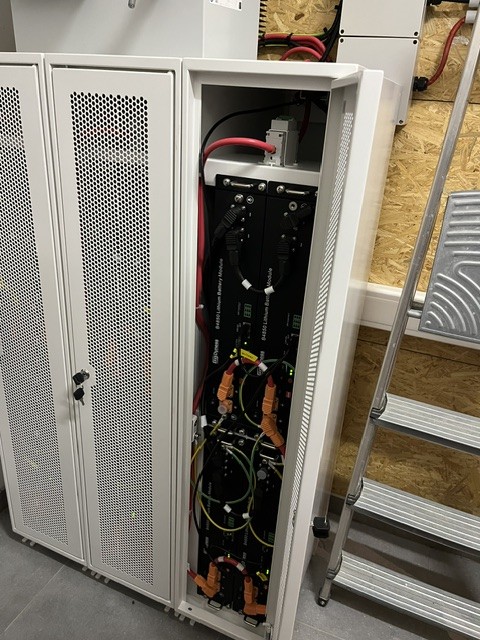 Open battery cabinet showing the lithium battery modules and the cabling