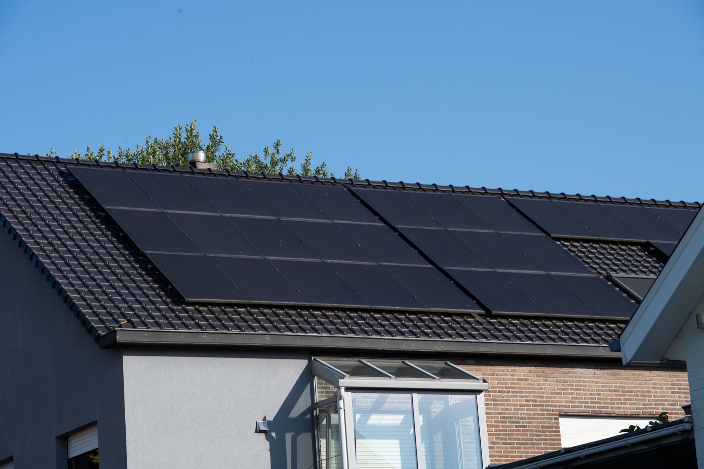 Solar panels along the long roof plane of a bungalow with a veranda