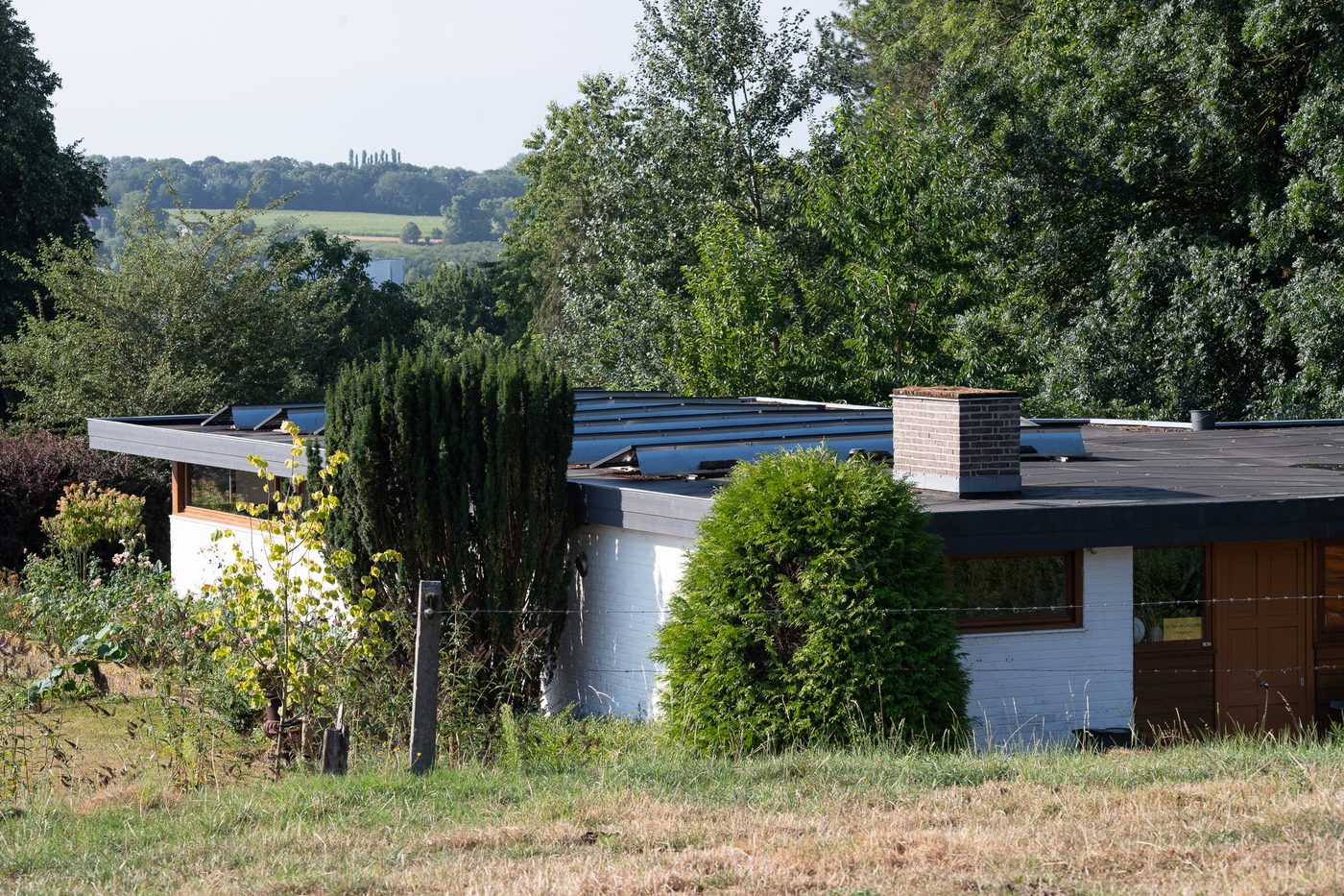 Solar panels on the flat roof of a bungalow in a rural setting